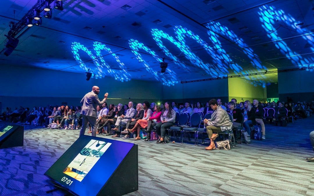 Keynote speaker presenting at a major corporate event organized by SD Meetings, highlighting professional event production and audience engagement