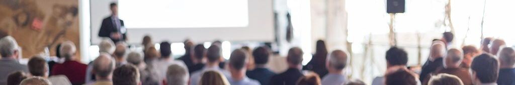 July Blog Post Cover (2) Speakers presenting at a corporate event, engaging with the audience and sharing industry insights during a professional conference or seminar
